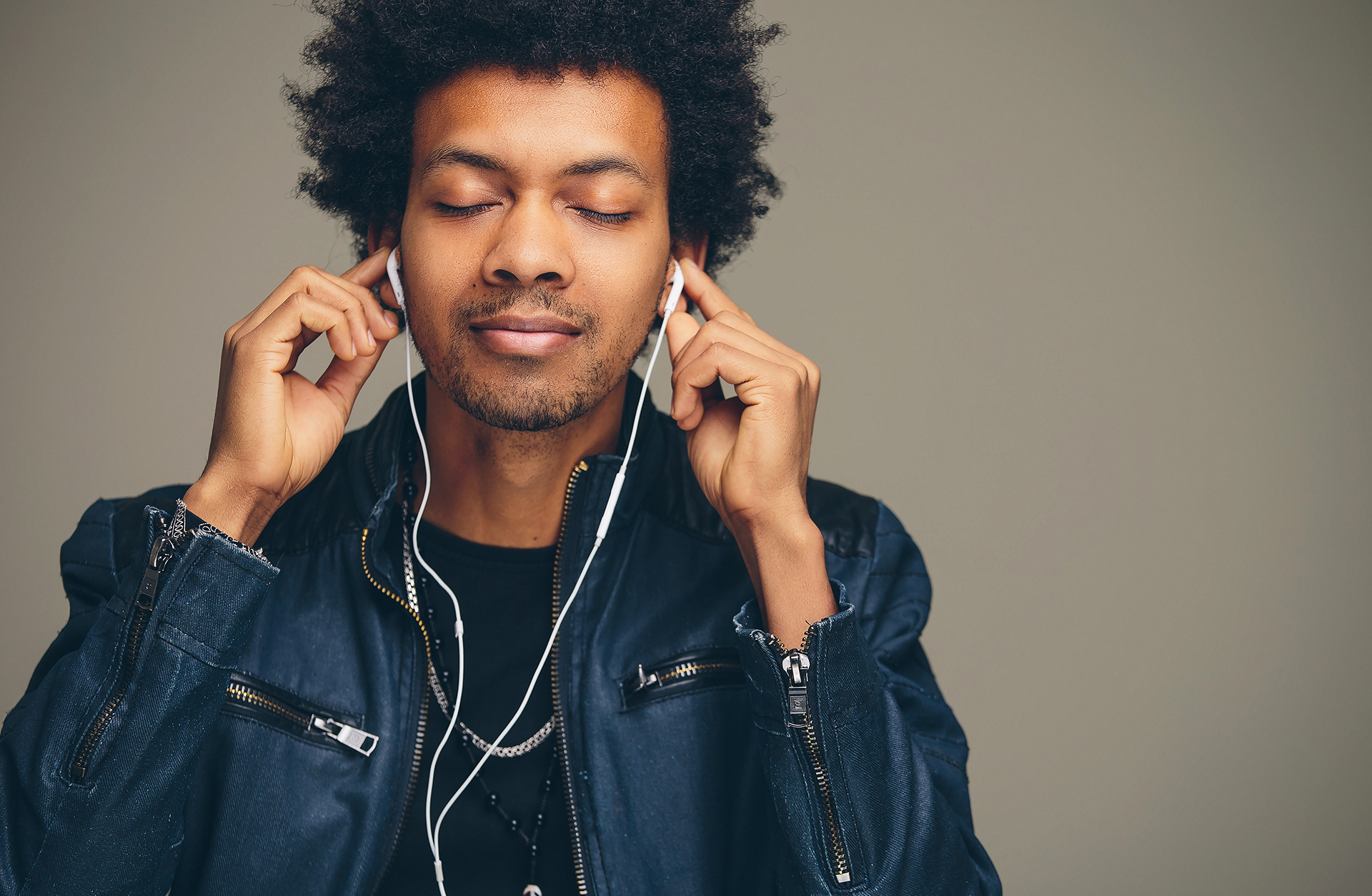 Kille med svart hår njuter av musik i hörlurar