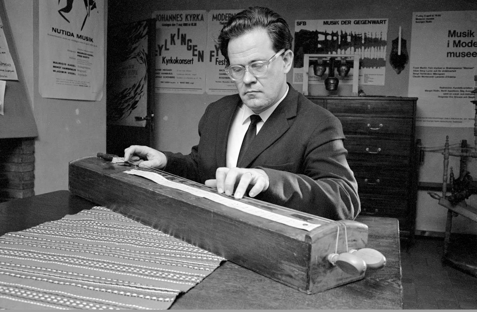 Svartvitt foto av Bengt Hambreus vid ett stränginstrument.