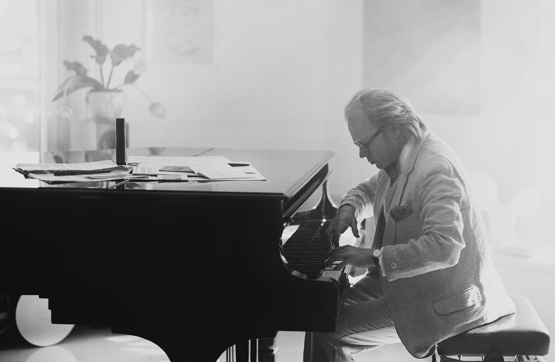 En svartvit bild med Roland Pöntien vid pianot