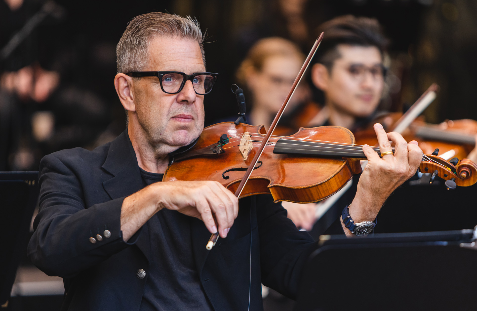 Man med glasögon spelar violin