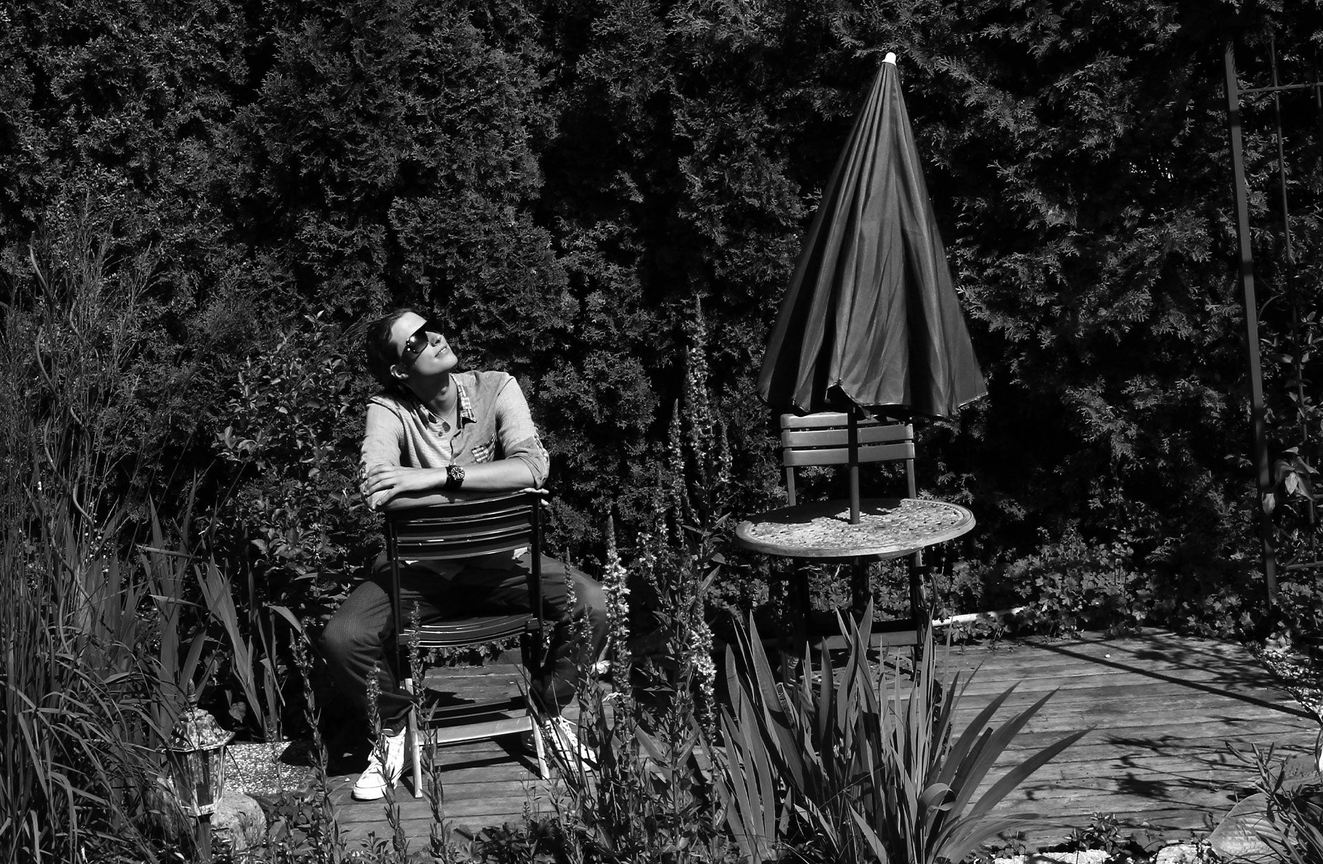 Ludwig Göransson sitter på en trädgårdsstol. Han har solglasögon och vänder sitt ansikte mot solen.