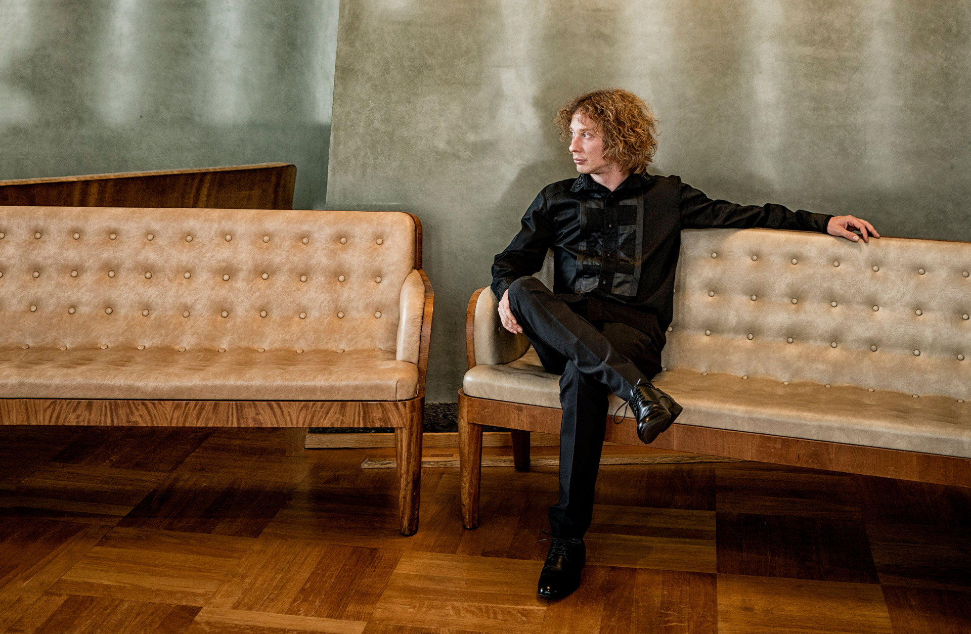 Santtu-Matias Rouvali sitter avspänt i en soffa i Konserthusfoajén.