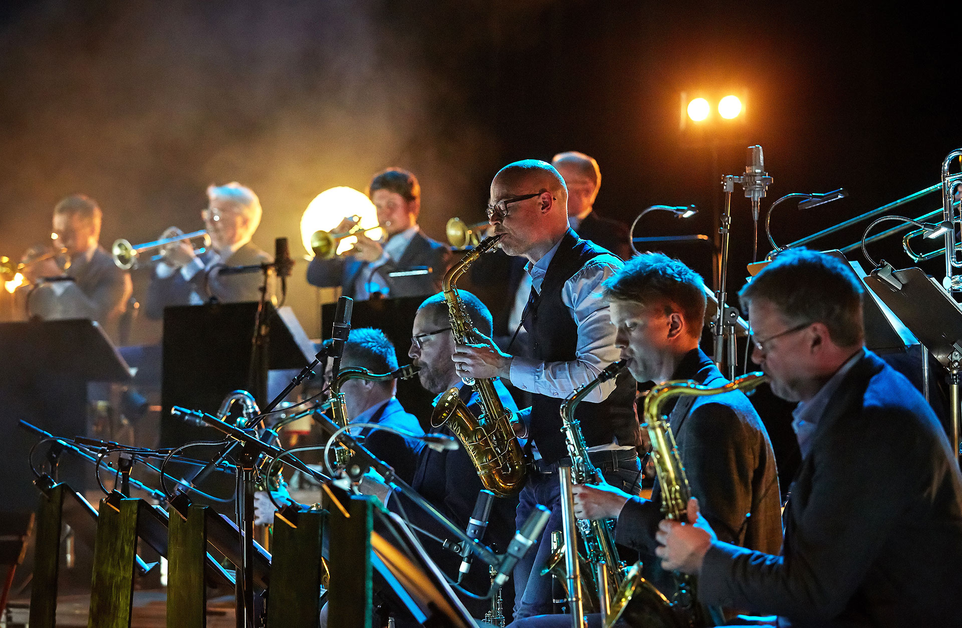 Saxofonister på rad i intensivt scenljus.