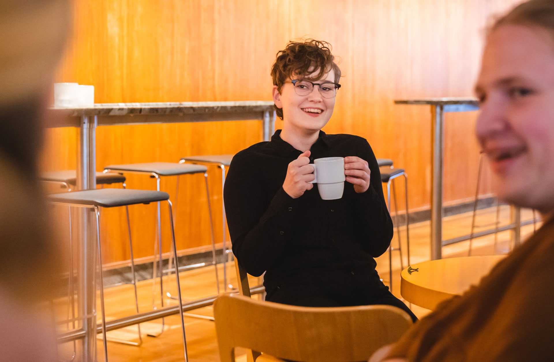 Ung glad kvinna med kaffekoppen i handen.