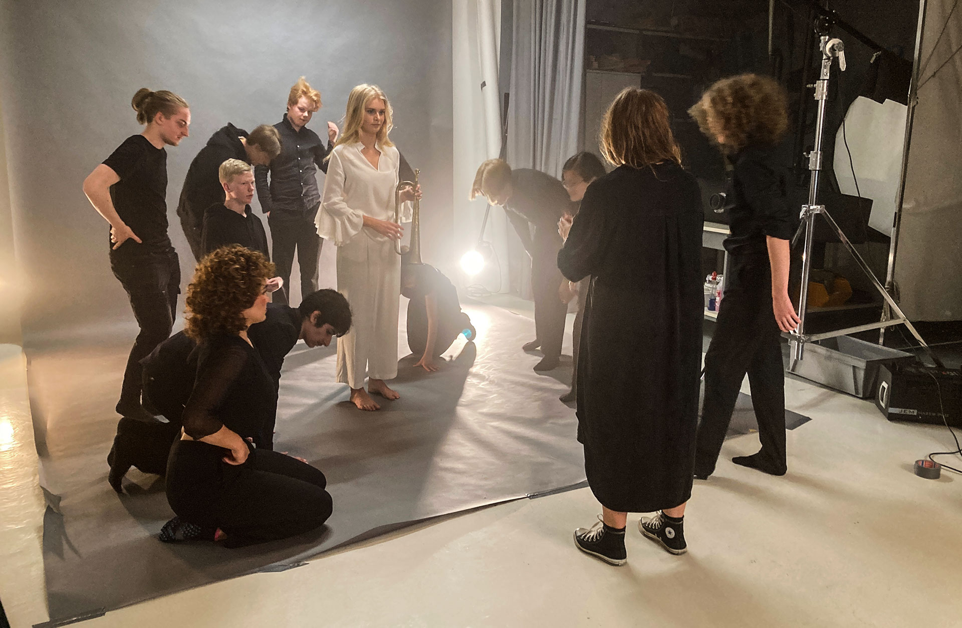 Ett antal svartklädda ungdomar i en fotostudio får instruktioner från fotografen.