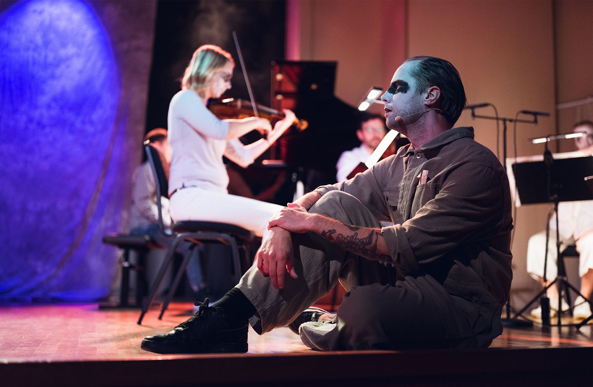 Rasmus Persson sitter i scenkläder vid scenkanten. Han medverkar i musikföreställningen Skräck i Stenhammarsalen.