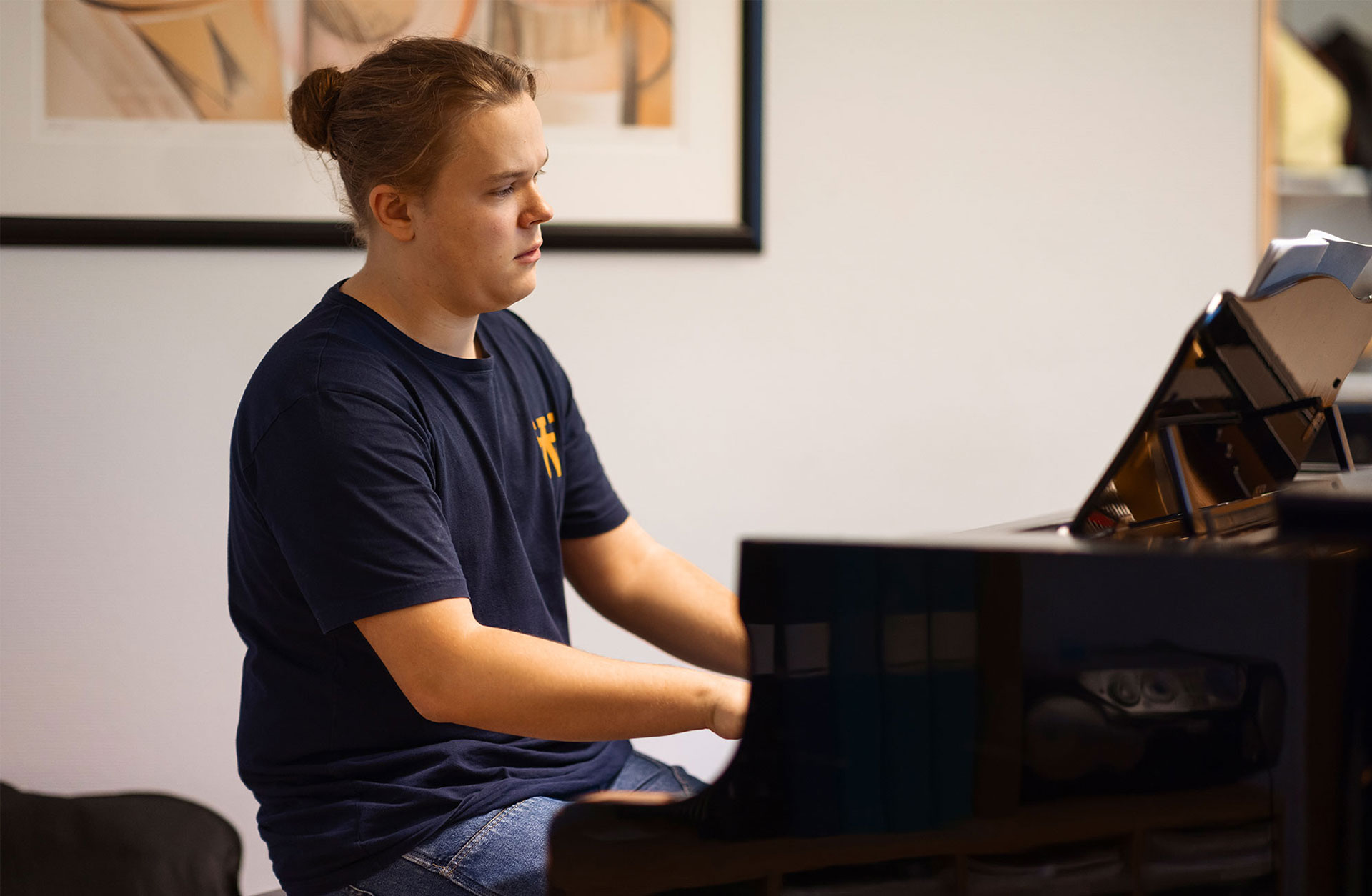 Valdemar sitter vid ett piano och spelar koncentrerat.
