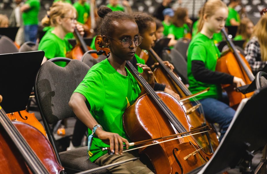 Koncentrerade barn spelar cello