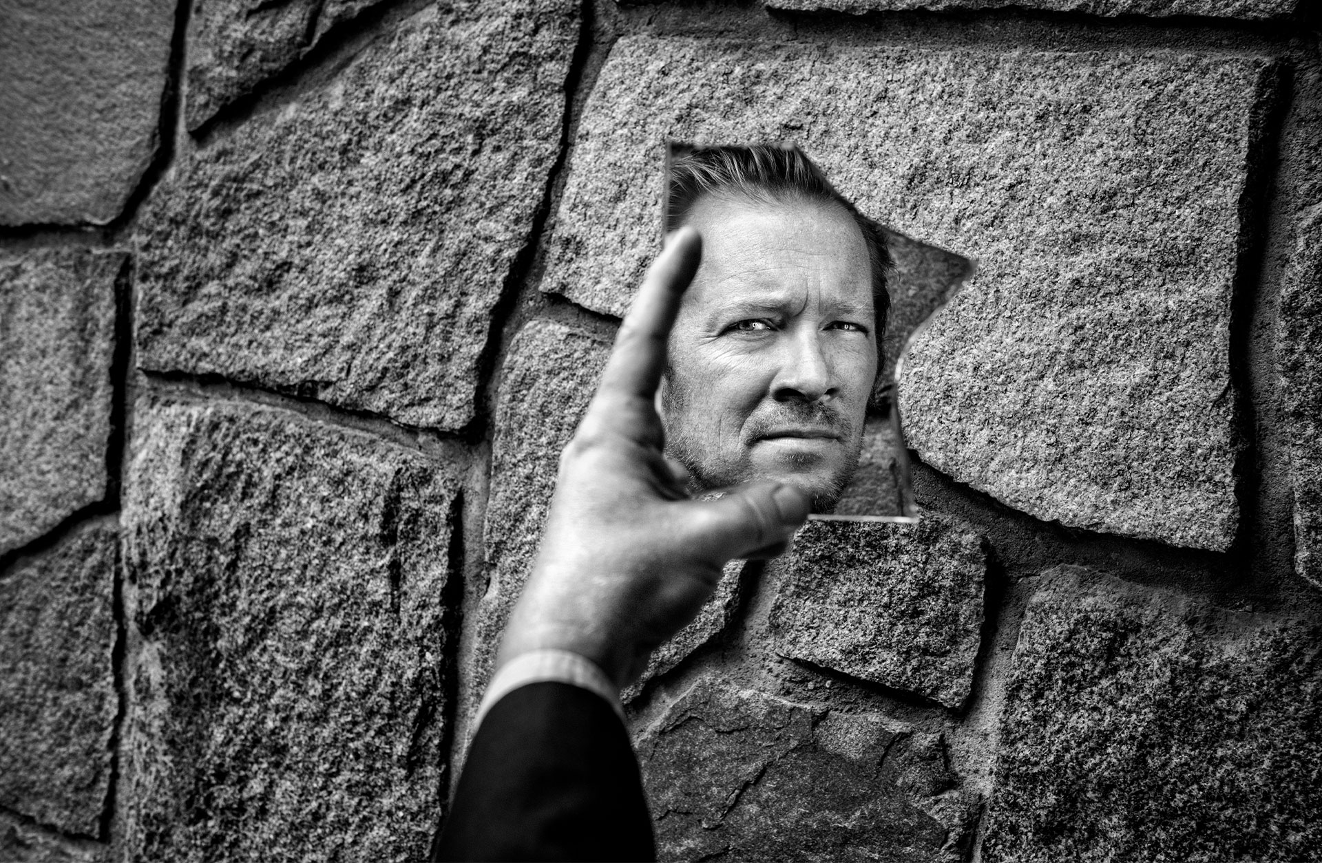 Fotot visar Johan Lindströms porträtt genom en spegelskärva.