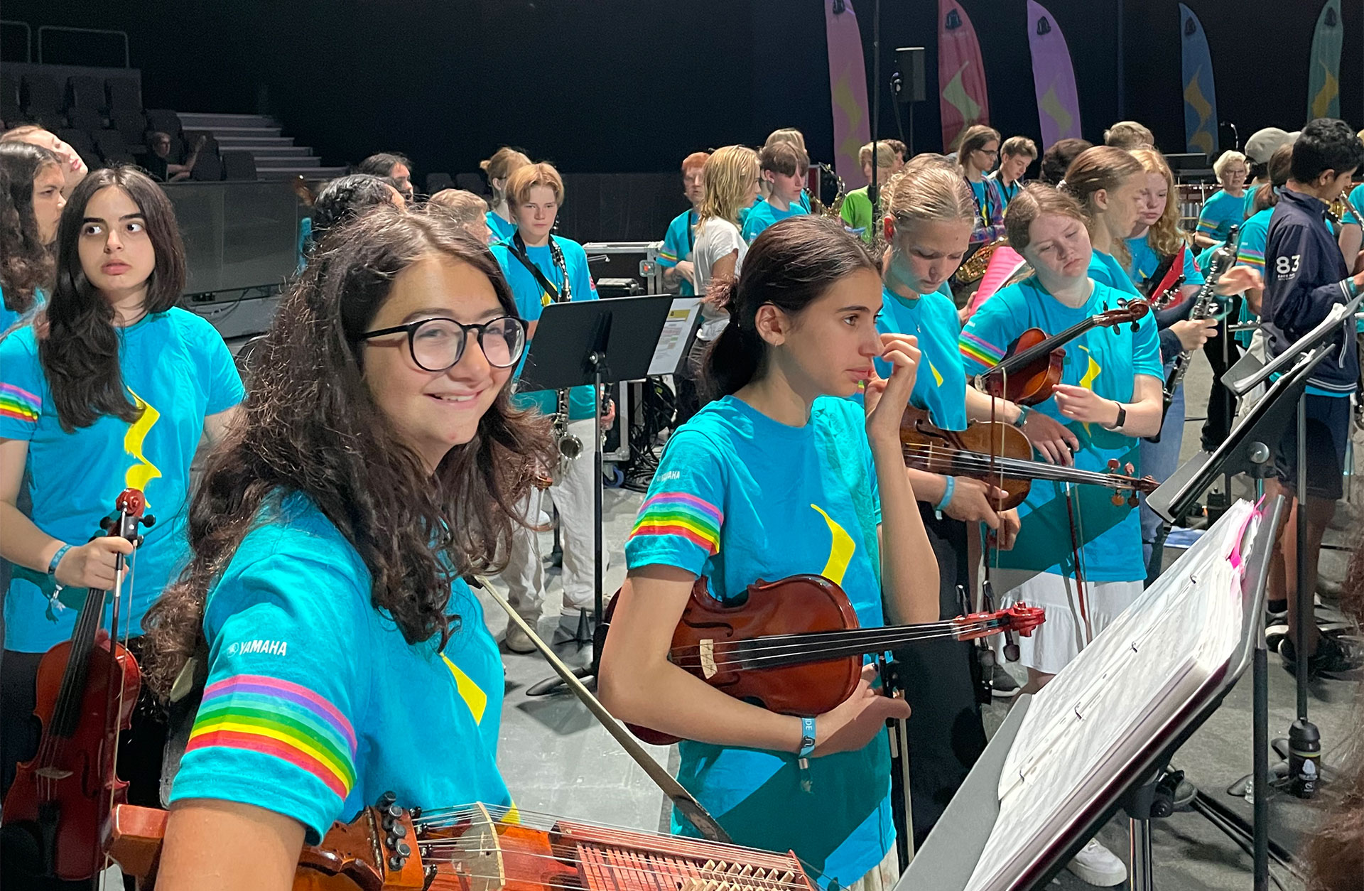 Viola står med sin nyckelharpa i orkestern.