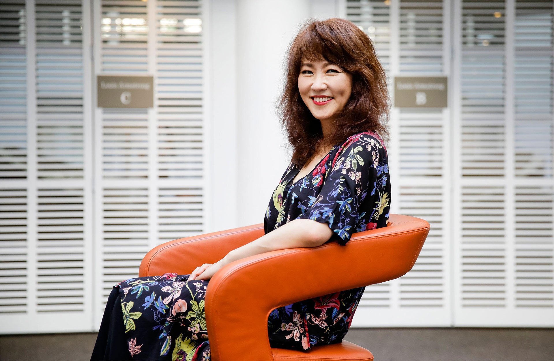Youn Sun-Nah sitter i en fåtölj och tittar glatt in i kameran.