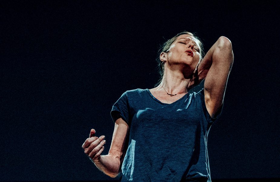 Barbara Hannigan står med huvud och ena hand riktat uppåt mot svart bakgrund.