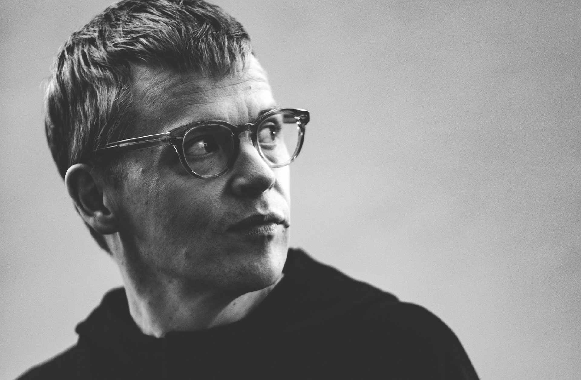 Svartvit bild av Pekka Kuusito. Det är en ansiktsbild och han vänder huvudet åt sidan.