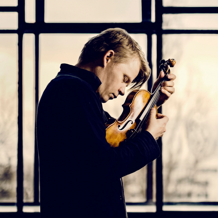 Pekka Kuusisto står i profil framför ett fönster och knäpper på strängarna på sin fiol.