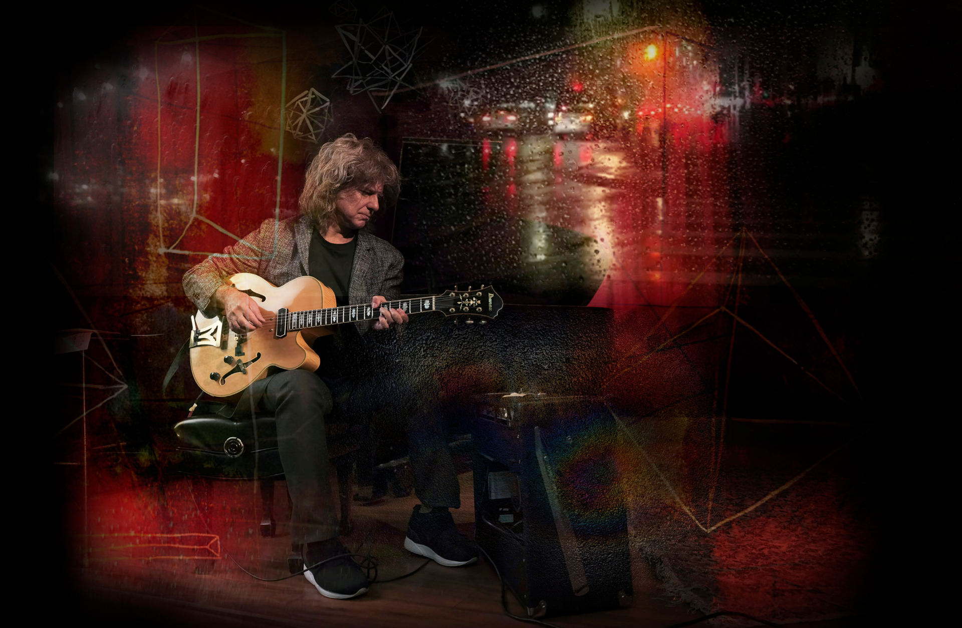 En man sitter på en stol och spelar gitarr
